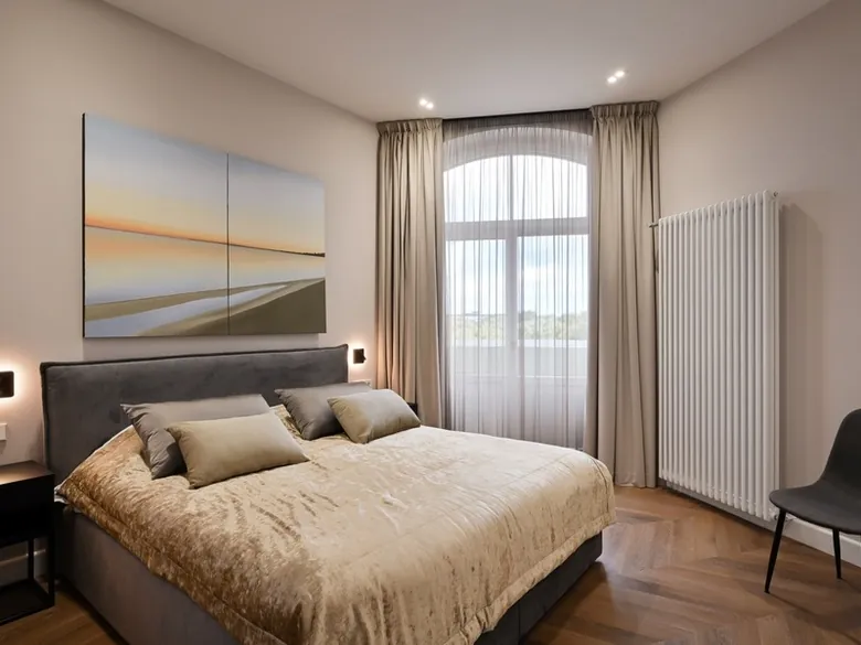 Bedroom with a double bed and tall historic windows